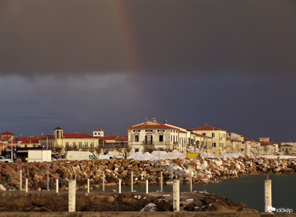 Sötét az ég, a házakat bevilágítja a lemenő nap