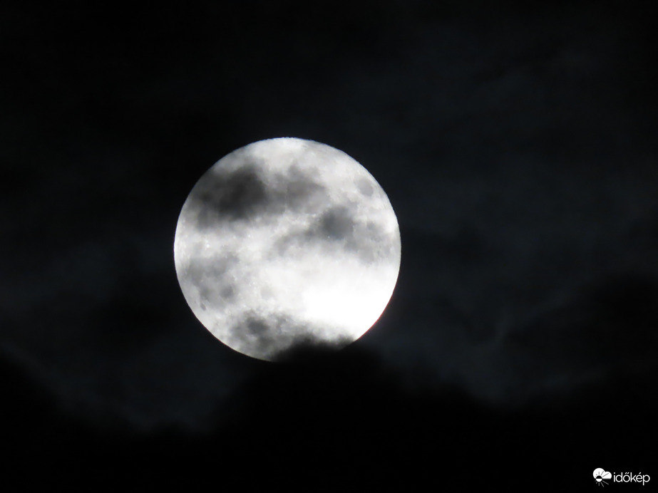 Telihold a felhők között