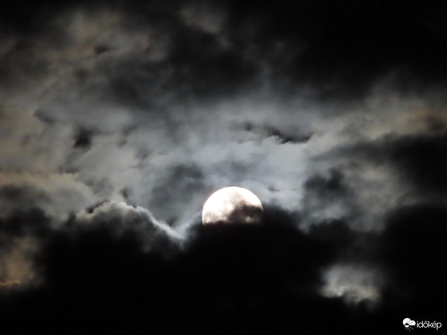 Felhők között bújkáló telihold