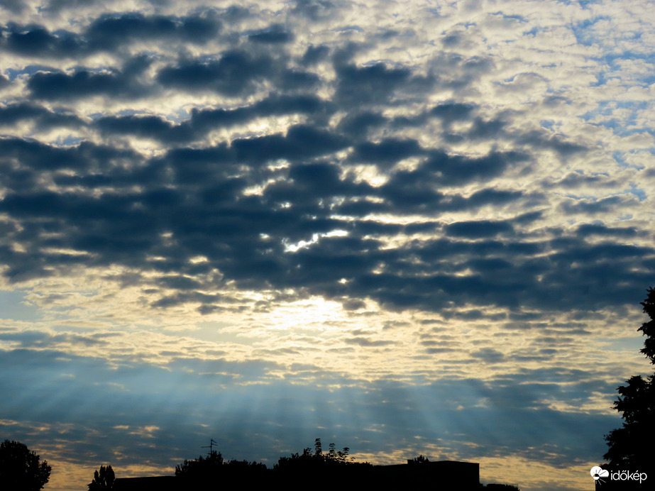 Felhők mögül ontja sugarait a Nap