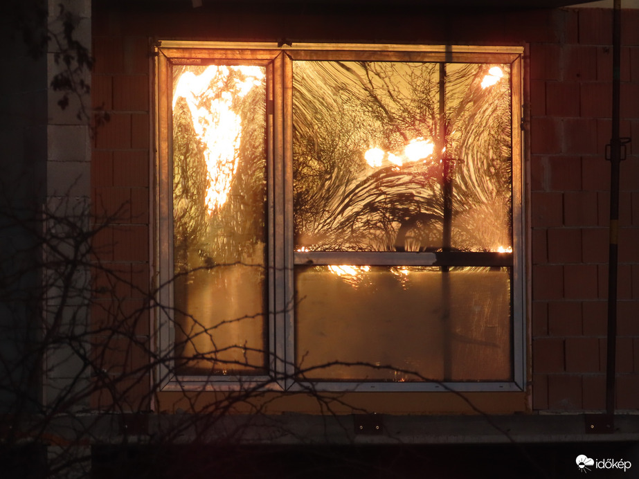 Napkelte fényei épülő ház ablakán