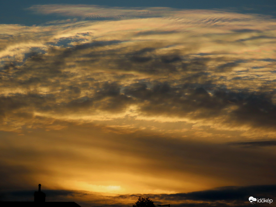 Naplemente fényei irizáló felhőkkel a magasban