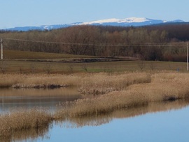 Dozmati víztározó távoli havas hegyekkel