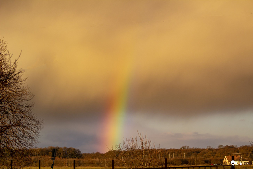 Mai szivárvány a város szélén naplemente előtt