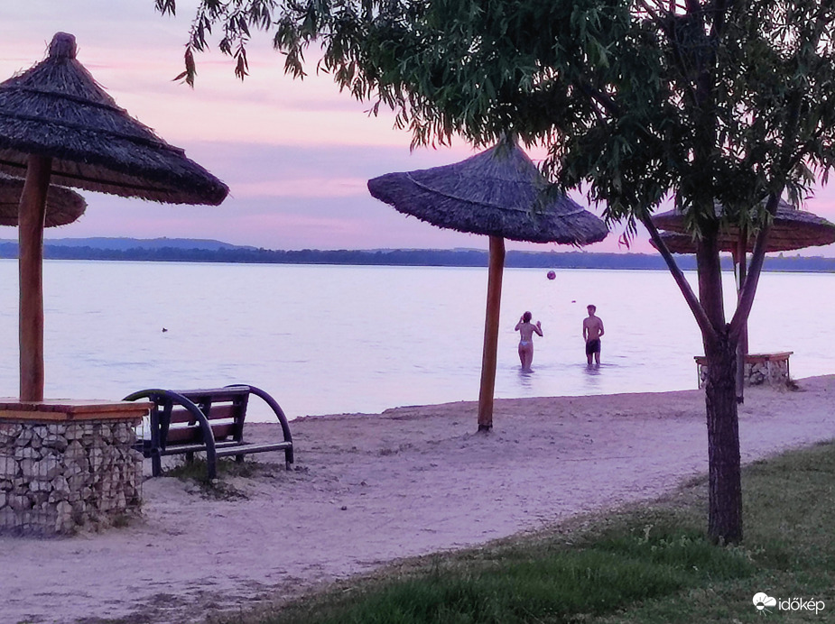 Röplabdázó fiatalok a Balatonban napnyugta után 
