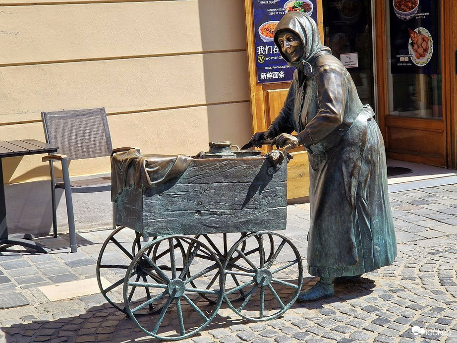 Kati néni, a fertályos asszony a tűző napsütésben is rendületlenül  kínálja portékáit!